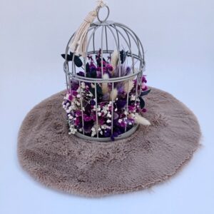 Jolie cage de décoration composée de fleurs séchées.