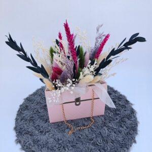 Petit sac rose composée de fleurs séchées.