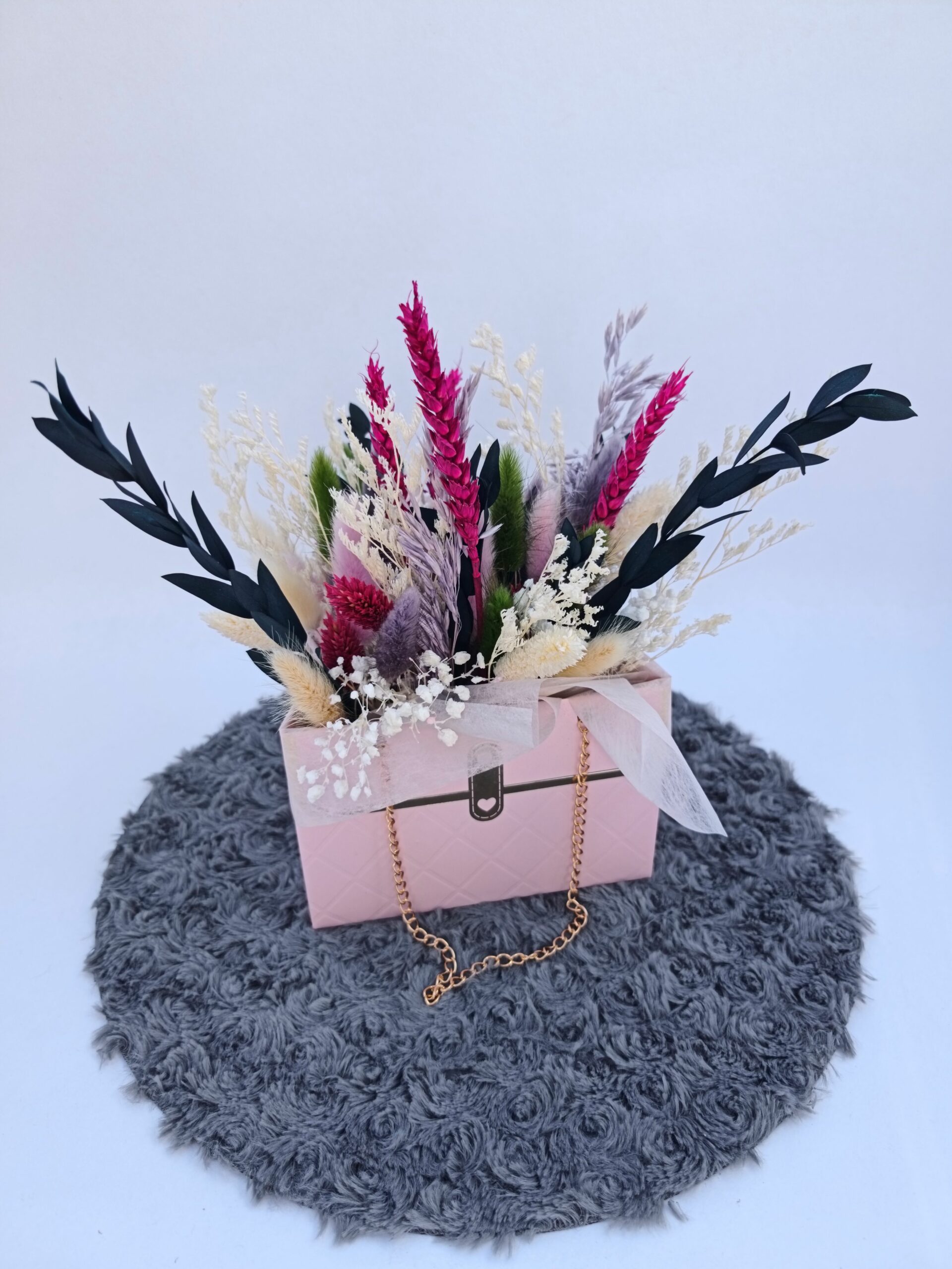 Petit sac rose composée de fleurs séchées.