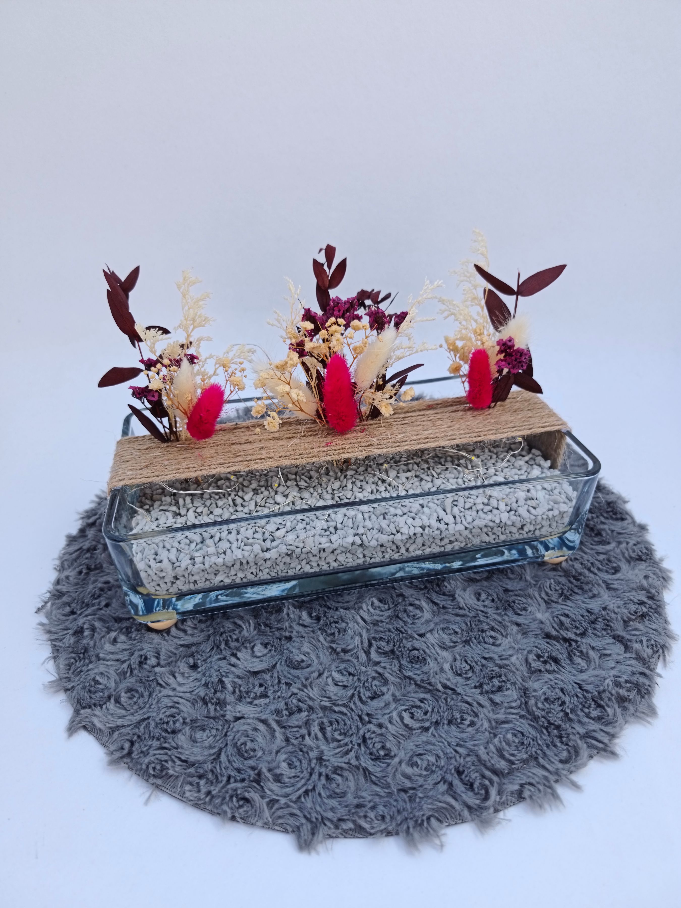 Jolie vase rectangle avec fleurs séchées et petite guirlande lumineuse